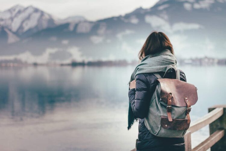 Travel Nursing Destinations Concept. A woman carrying a backpack looking into the distance
