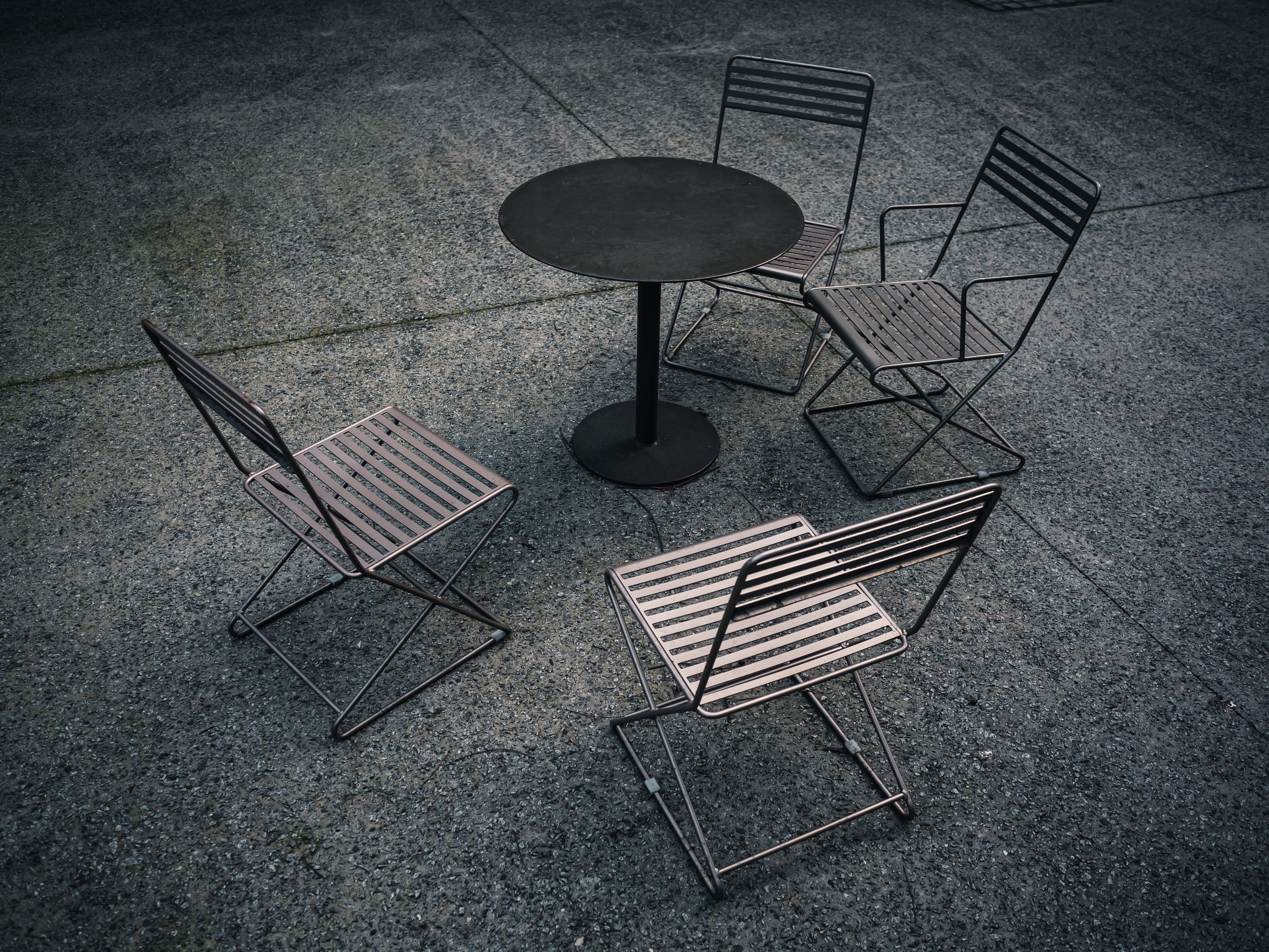 Minimalist patio seating with a metal table and chairs, representing metal-framed outdoor furniture.