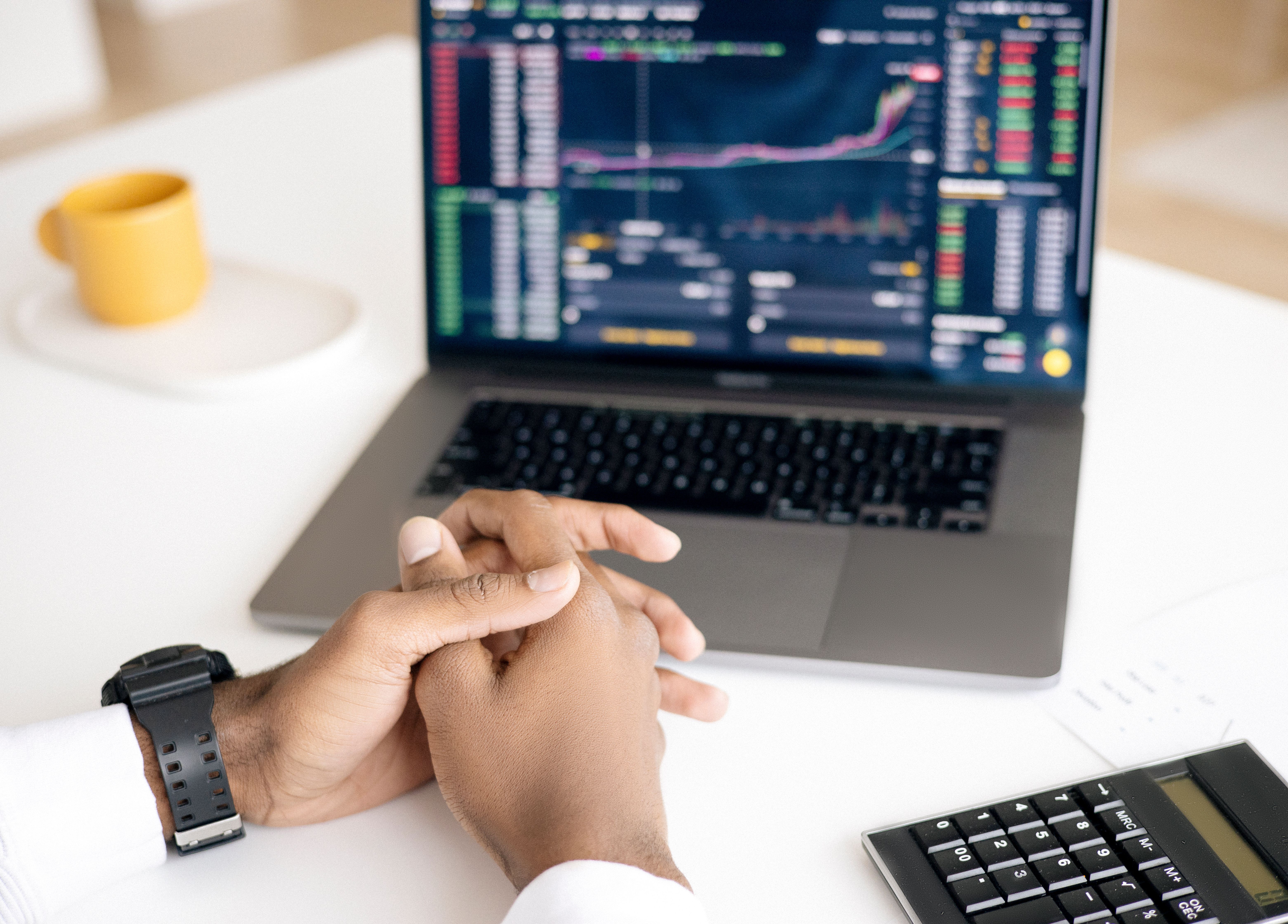 Person reviewing financial charts on a laptop at a desk while learning to follow daily market movements.